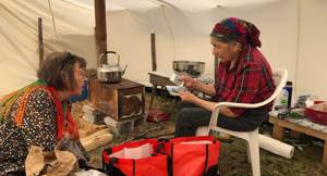 Elisabeth Utsi Gaup from Sami Allaskuvla visiting Elder Elisabeth Penasue at her tent. Photo: Marikaisa Laiti